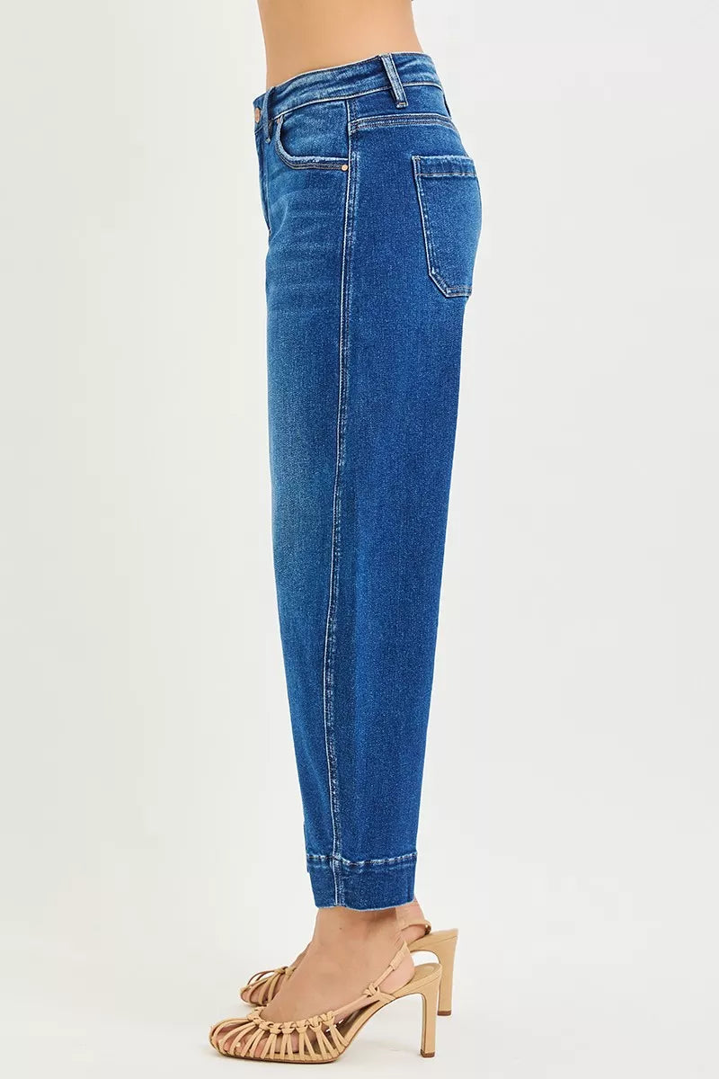 Dark wash Risen mid-rise crop barrel jeans from Trendsi, with a relaxed fit and rolled cuffs, shown on a model.