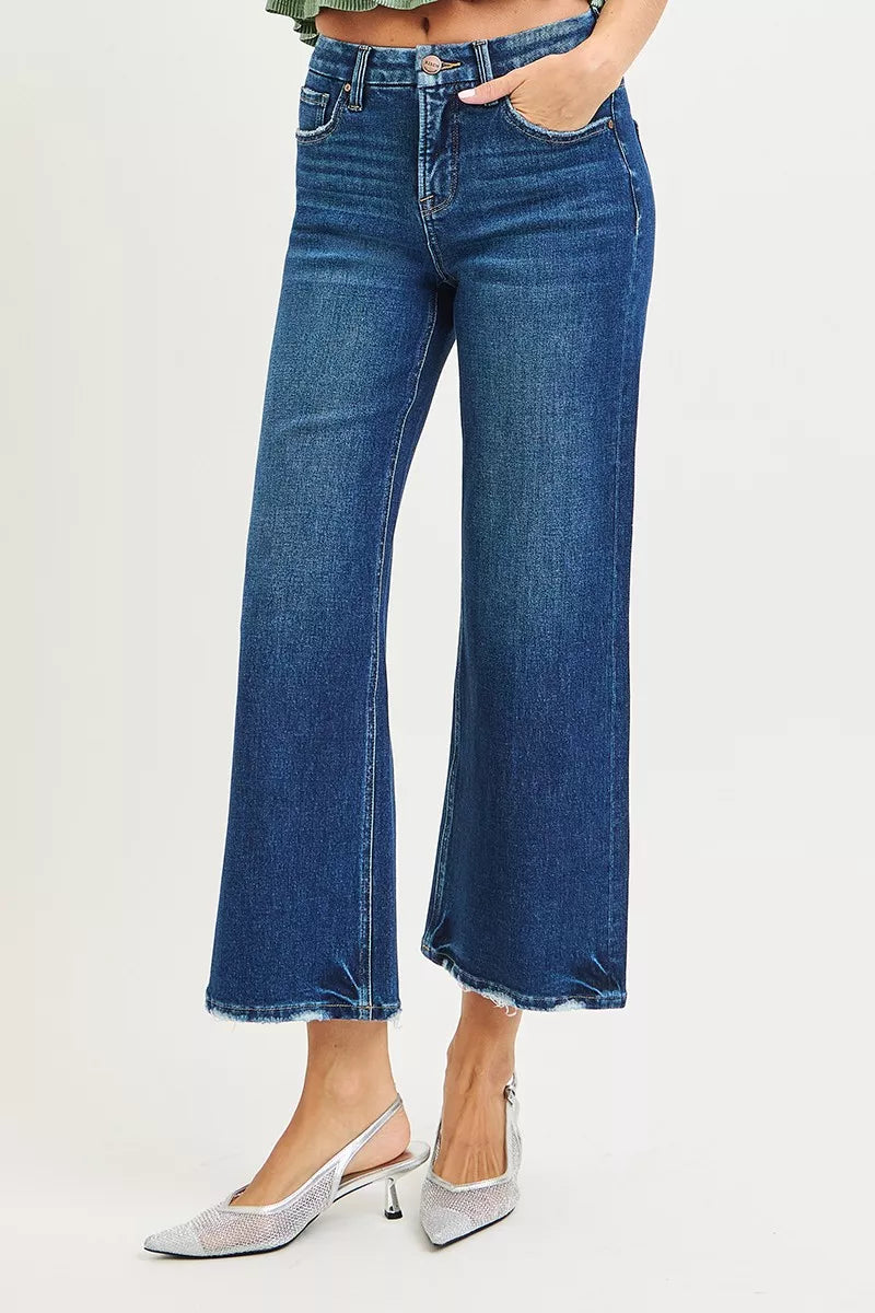 Dark pair of RISEN Tummy Control 4-Way Stretch High-Rise Crop Wide Leg Jeans by Trendsi, shown on a model.