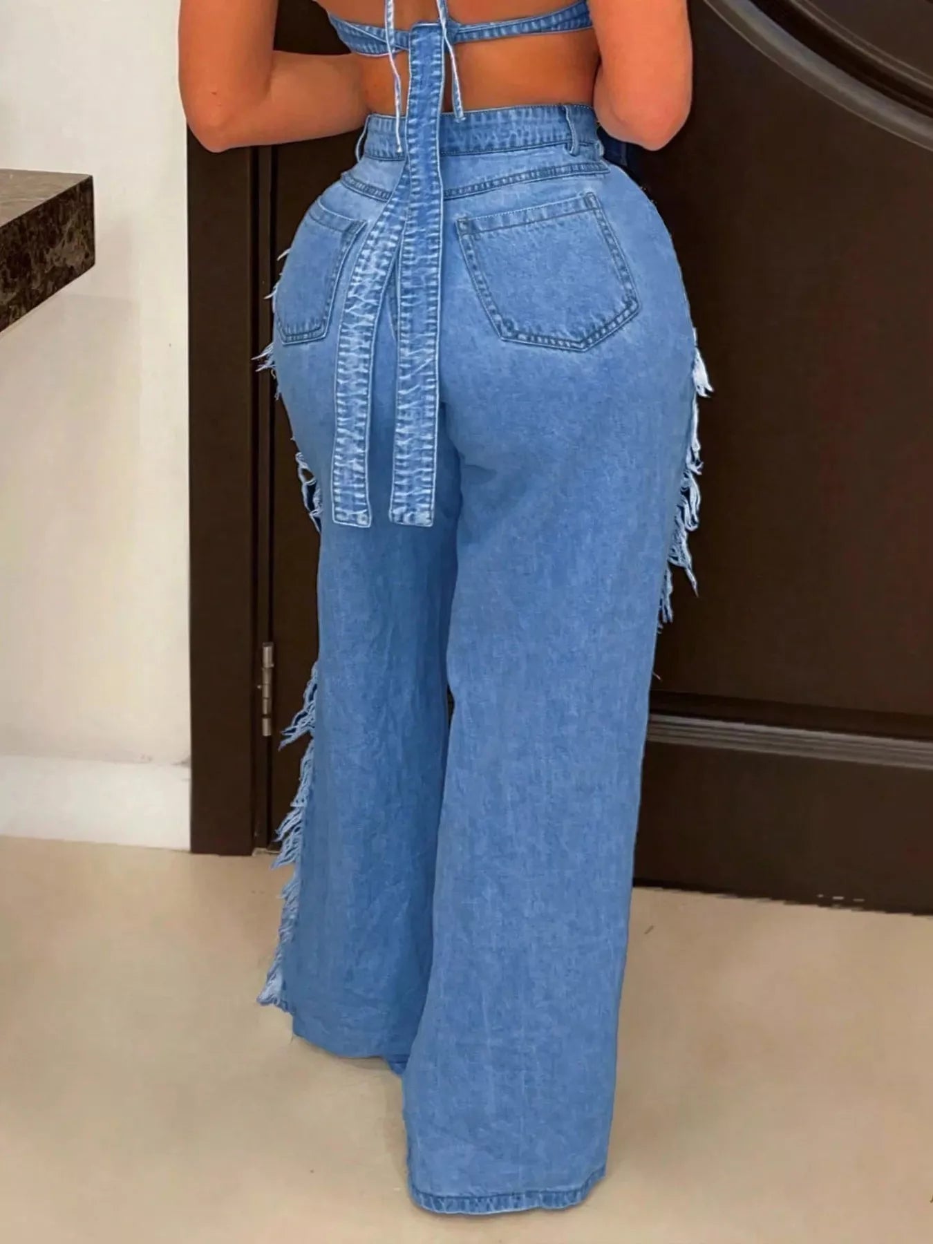 Dark blue distressed wide-leg jeans from Trendsi, showcasing a relaxed fit and ripped details on the denim fabric.