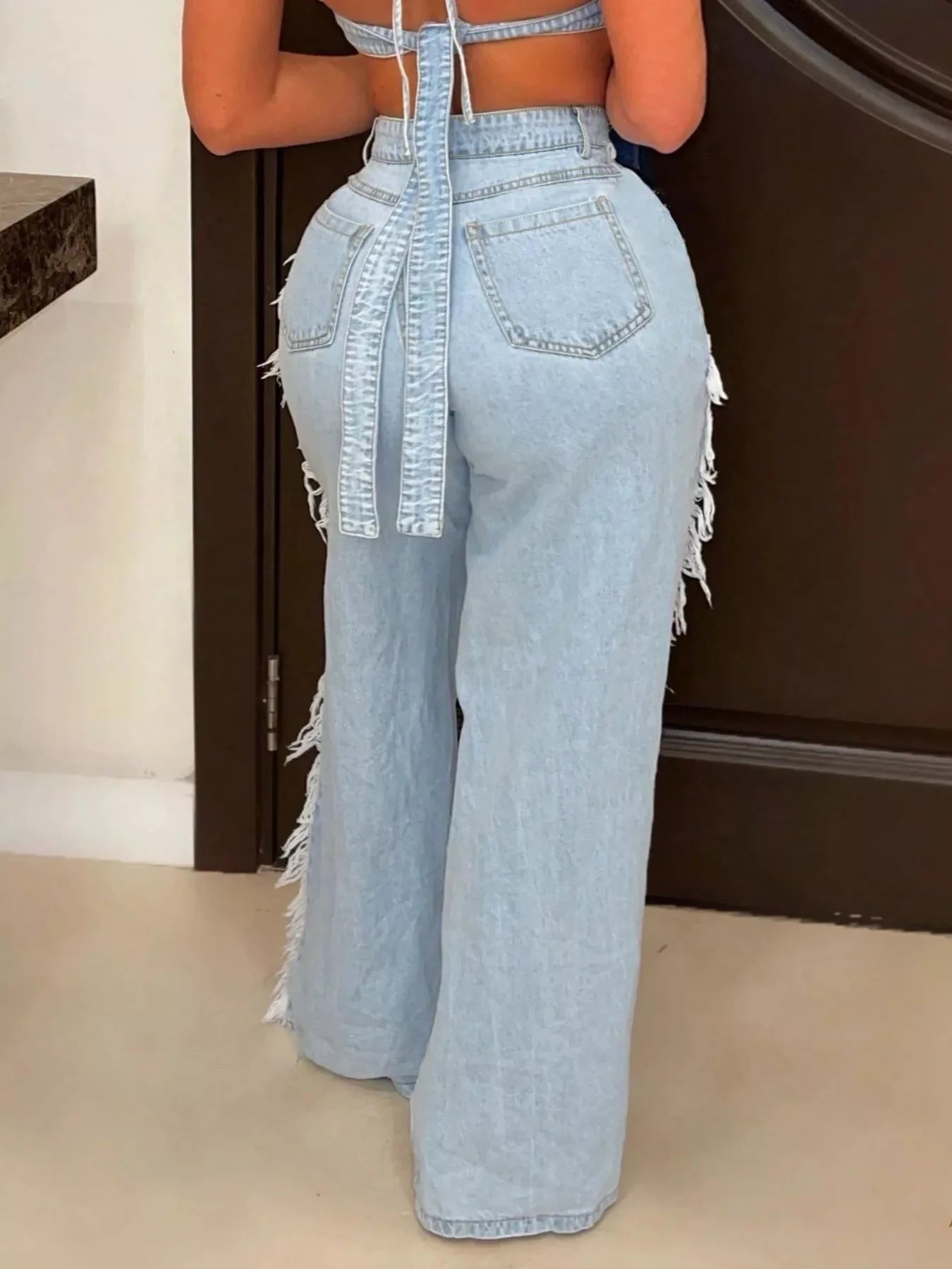 Dark blue distressed wide-leg jeans by Trendsi, featuring a relaxed fit and ripped details, displayed on a model.