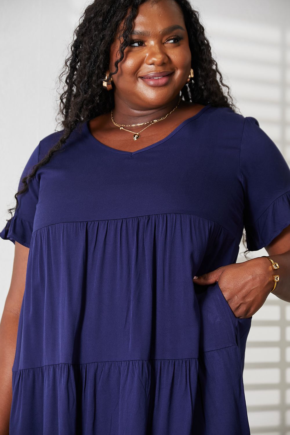 Dark blue Mandy V-neck flounce sleeve tiered dress from Trendsi, showcasing a stylish, flowy design with layered tiers.