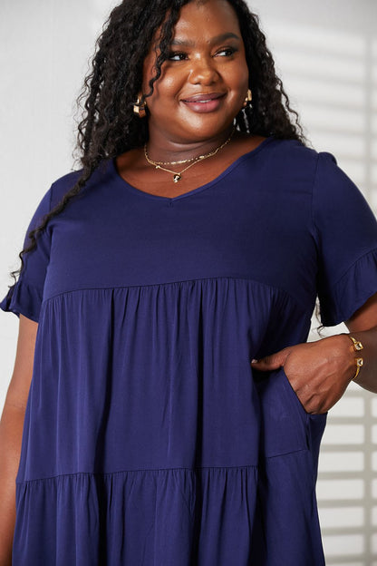 Dark blue Mandy V-neck flounce sleeve tiered dress from Trendsi, showcasing a stylish, flowy design with layered tiers.