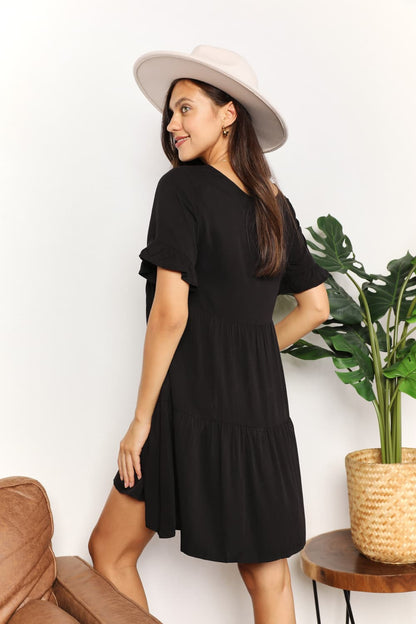 Dark blue Mandy V-Neck Flounce Sleeve Tiered Dress by Trendsi, showcasing its flowy layered design and stylish short sleeves.