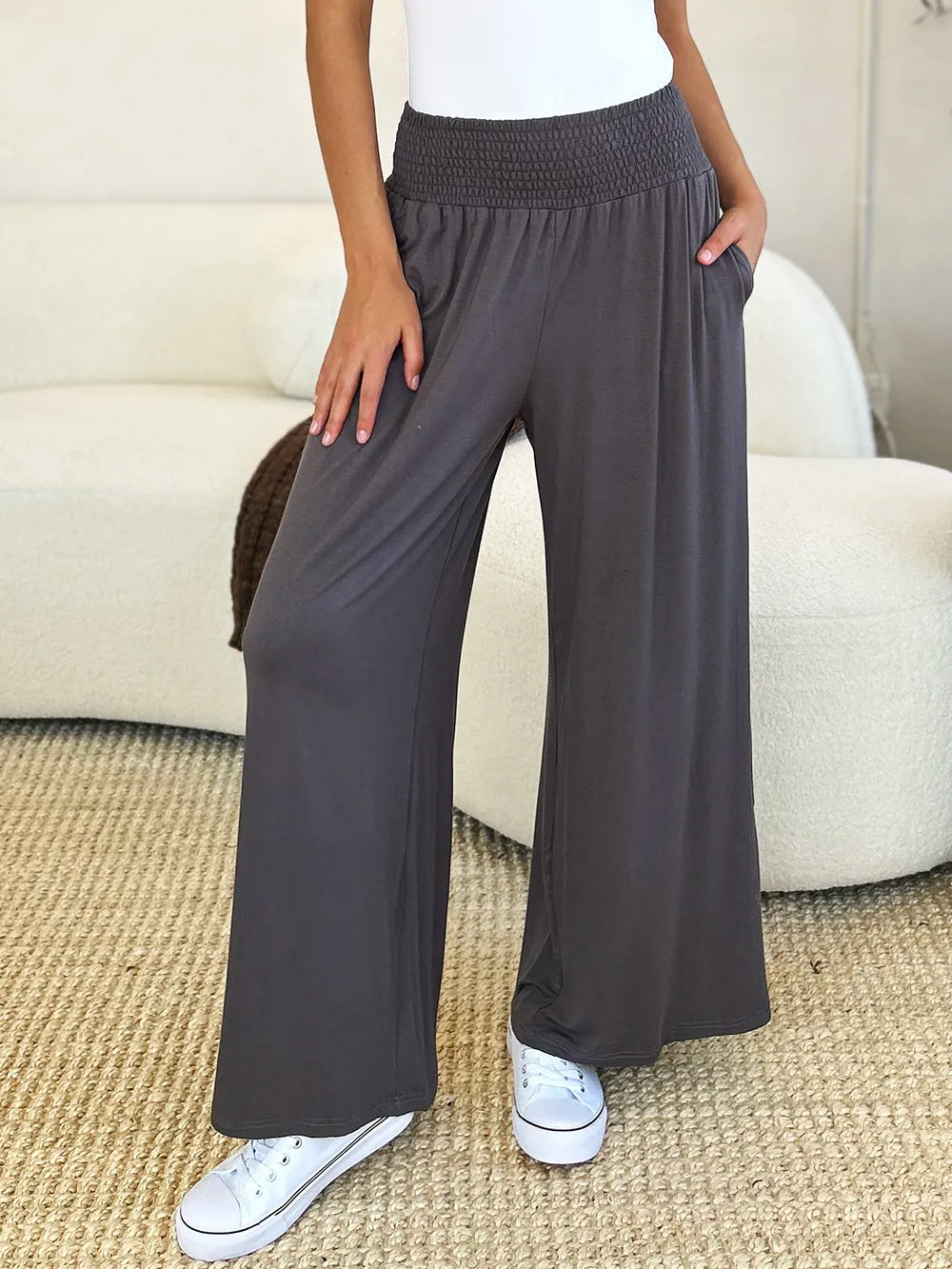 Dark gray Trendsi Basic Bae full-size smocked wide waistband wide-leg pants laid flat on a white background.