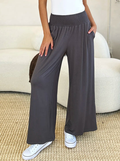 Dark gray Trendsi Basic Bae full-size smocked wide waistband wide-leg pants laid flat on a white background.