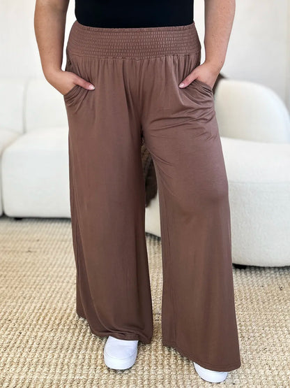 Dark gray Basic Bae full-size smocked wide waistband wide-leg pants by Trendsi, shown on a model highlighting relaxed fit and comfortable style.