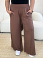 Dark gray Basic Bae full-size smocked wide waistband wide-leg pants by Trendsi, shown on a model highlighting relaxed fit and comfortable style.