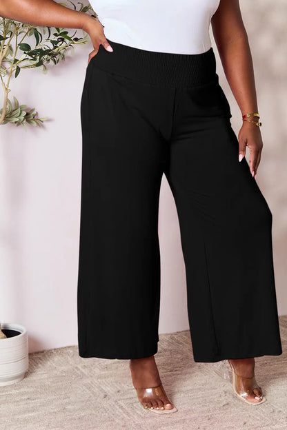 Dark gray Basic Bae full-size smocked wide waistband wide-leg pants by Trendsi, displayed on a hanger.