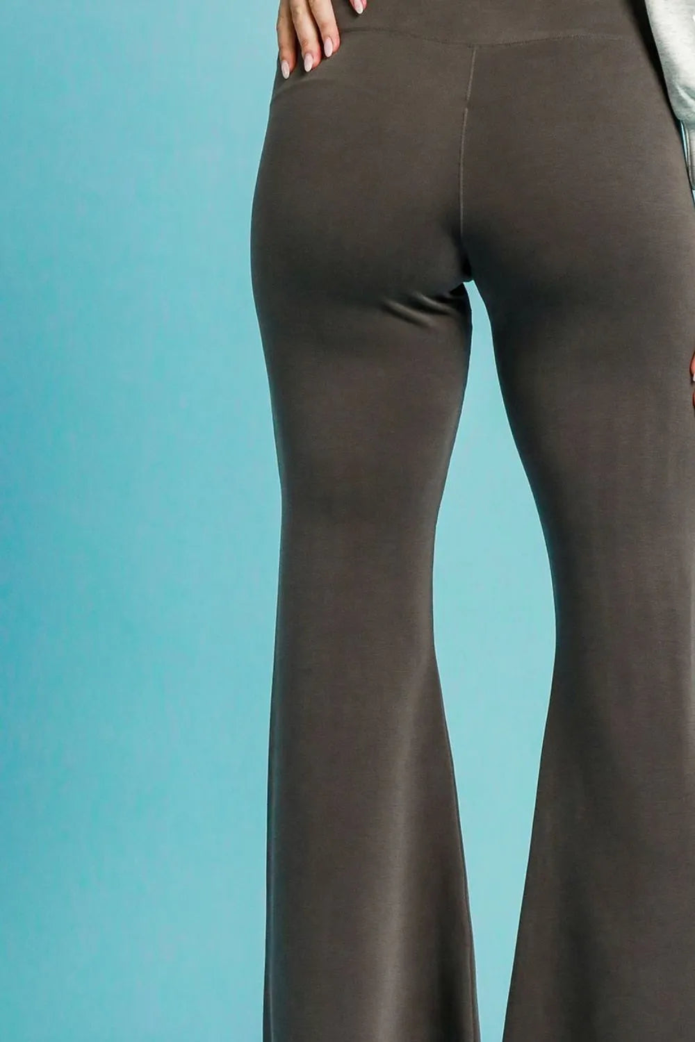 Dark gray Umgee high-waisted flare leggings shown on a model, featuring a fitted waist and flared leg design.