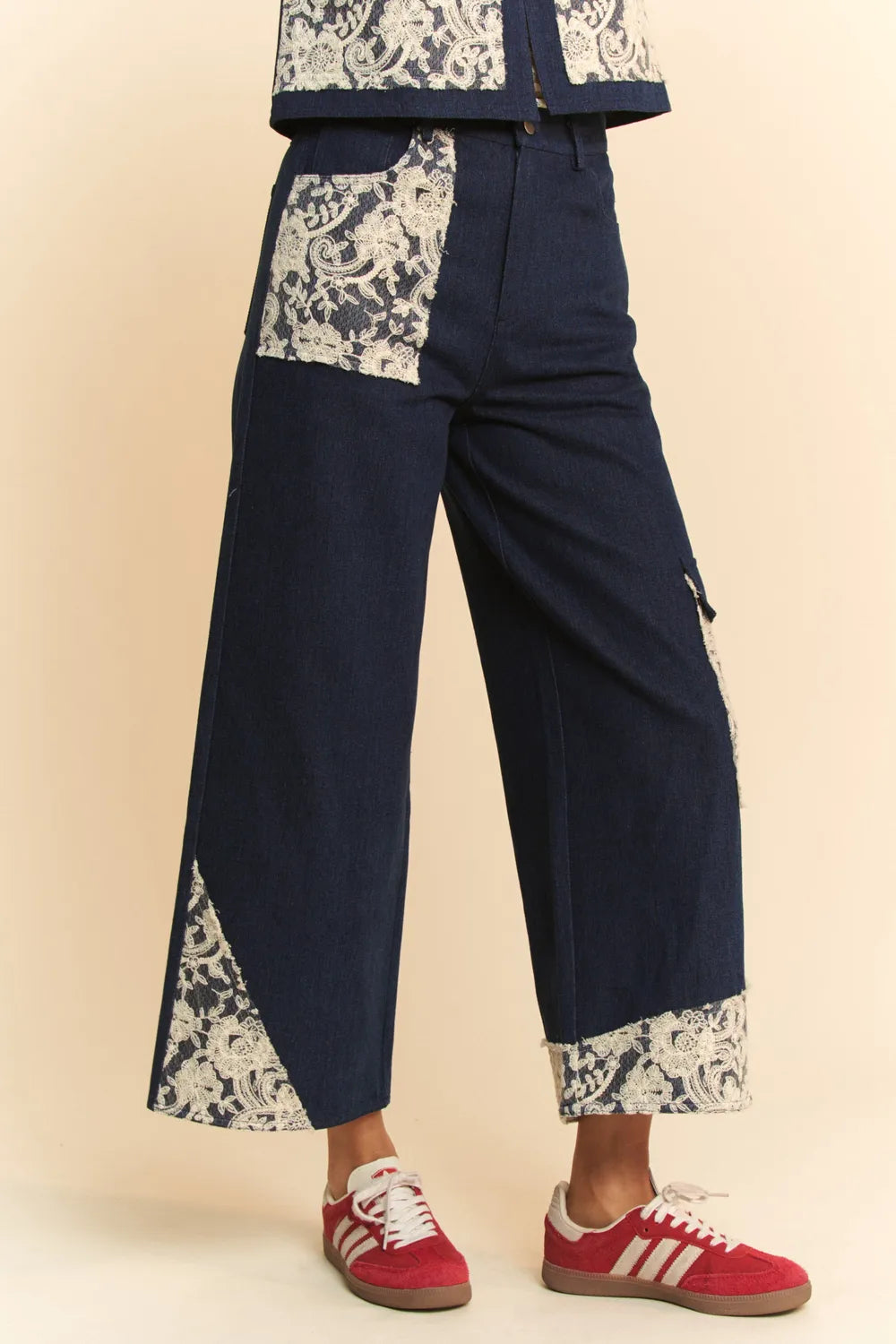 Dark wash Davi & Dani lace applique wide-leg jeans with decorative lace details and a relaxed fit, styled for a casual look.