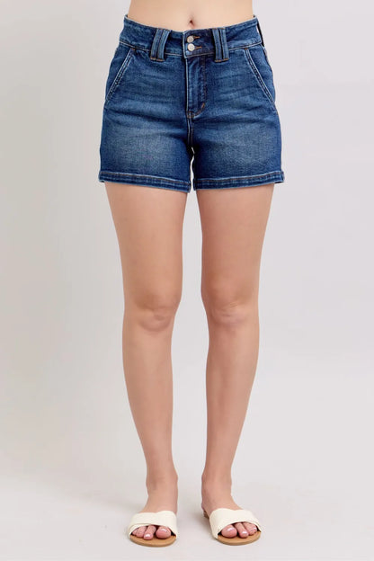 Plus size Judy Blue denim shorts with double button waistband, dark wash, featuring a relaxed fit and classic denim styling.