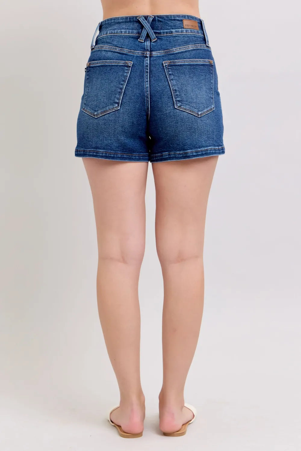 Plus size Judy Blue denim shorts with double button waistband, dark wash, and relaxed fit, perfect for casual summer wear.