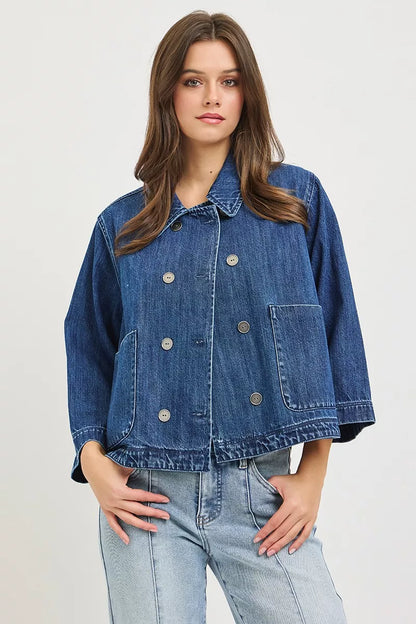 Dark blue RISEN double-breasted flowy cropped denim jacket with long sleeves and classic collar, styled on a mannequin.