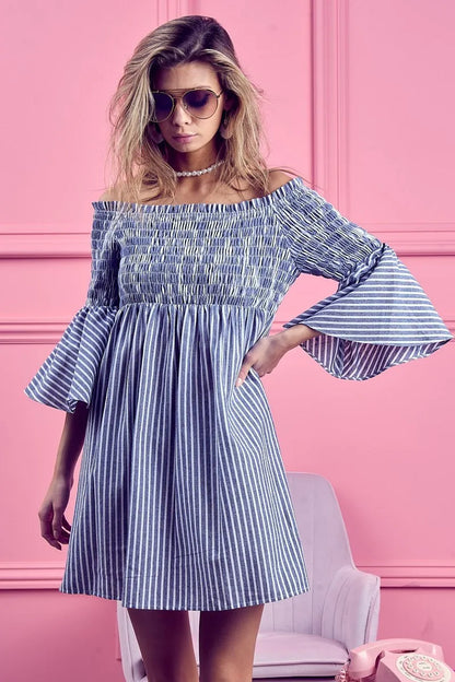 BiBi Smocked Off-Shoulder Striped Dress by Trendsi featuring a fitted bodice and flowing skirt with blue and white stripes.