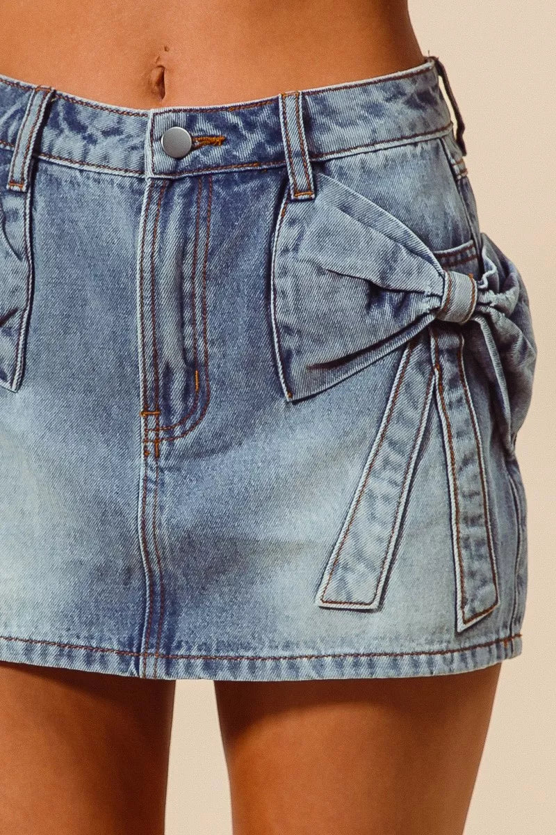 Trendsi SO ME bow knot pocket denim mini skirt featuring a stylish design with front pockets and a fitted waistband.