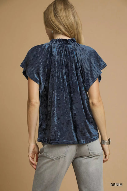 Umgee crushed velvet pleated blouse in a relaxed fit, shown in a stylish fashion shot. Perfect for chic, casual outfits.