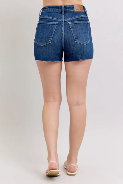 Plus size Judy Blue high waist denim shorts with criss-cross waistband and classic blue wash, front view showing fit and style