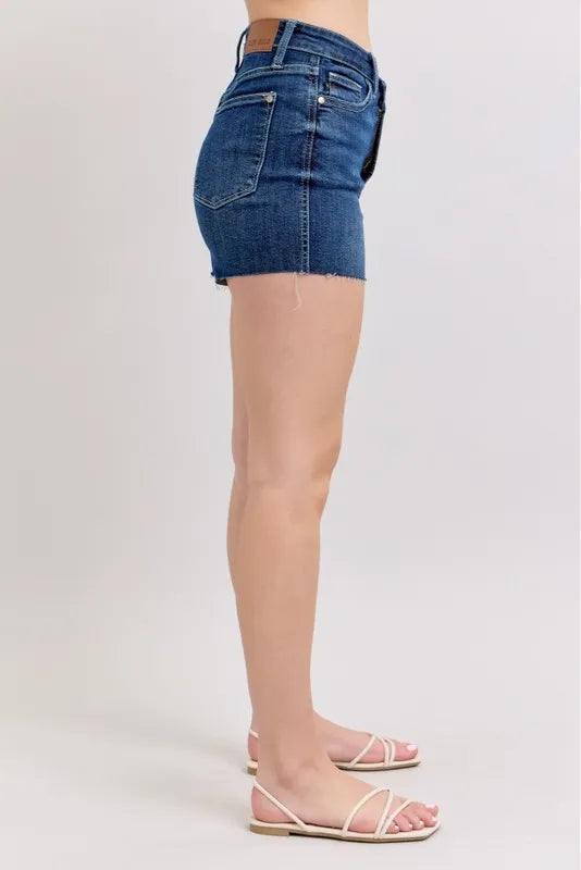 Plus size Judy Blue high waist denim shorts with criss-cross waistband and distressed details, displayed on a model.