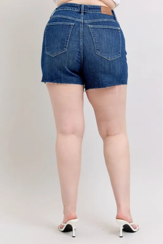 Plus size Judy Blue high waist denim shorts with criss-cross waistband and distressed details, full length view.