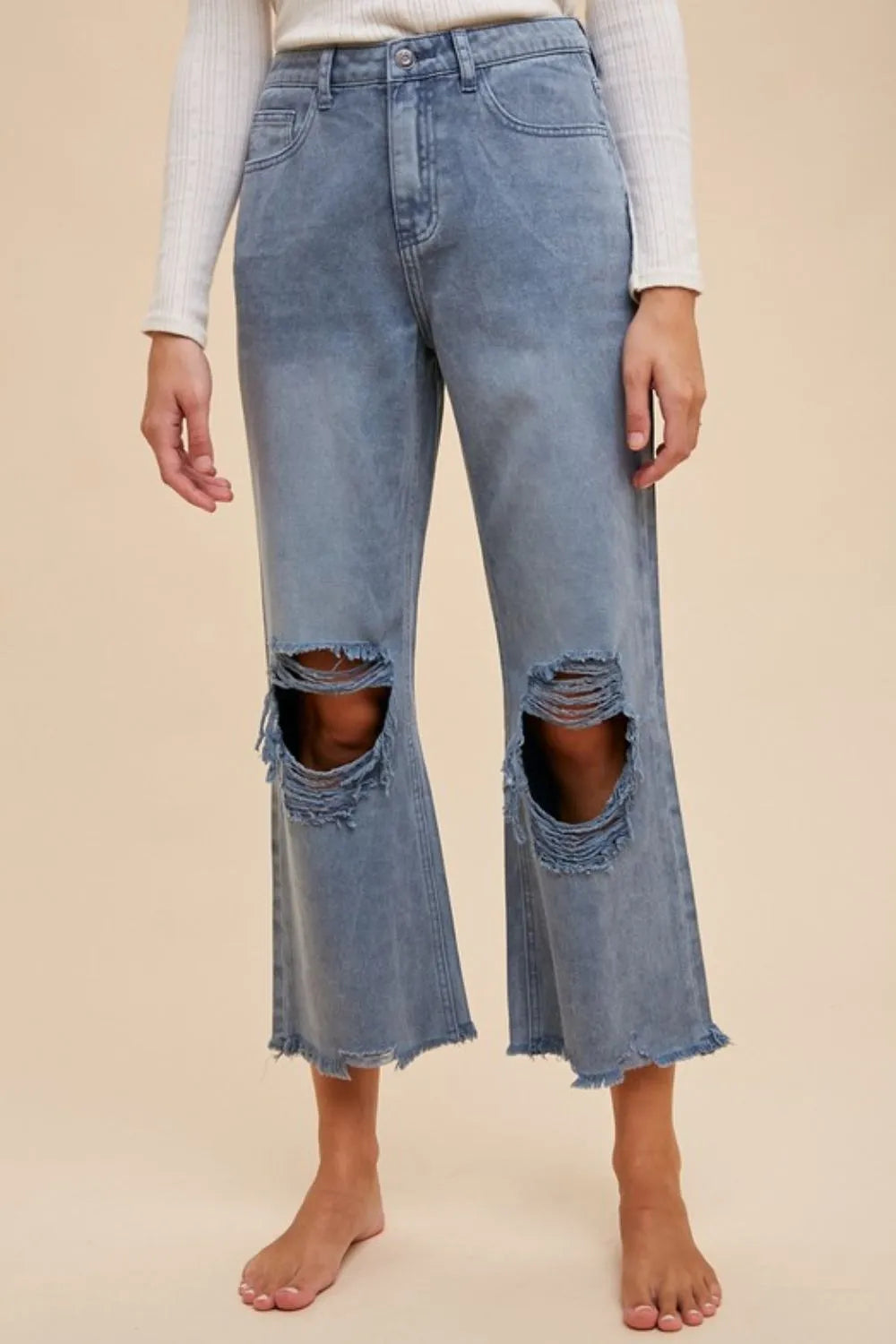 Dusty blue Annie Wear distressed raw hem jeans by Trendsi with ripped details and frayed edges, showcasing a stylish casual look.