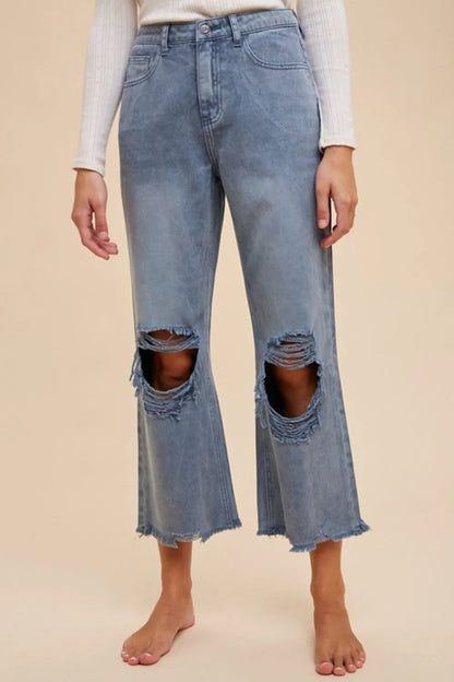 Dusty blue Annie Wear distressed raw hem jeans by Trendsi with ripped details and frayed edges, showcasing a stylish casual look.