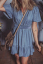 Dusty blue denim mini dress by Trendsi with ruffled hem, smocked waist, and flutter sleeves, perfect for casual summer wear.