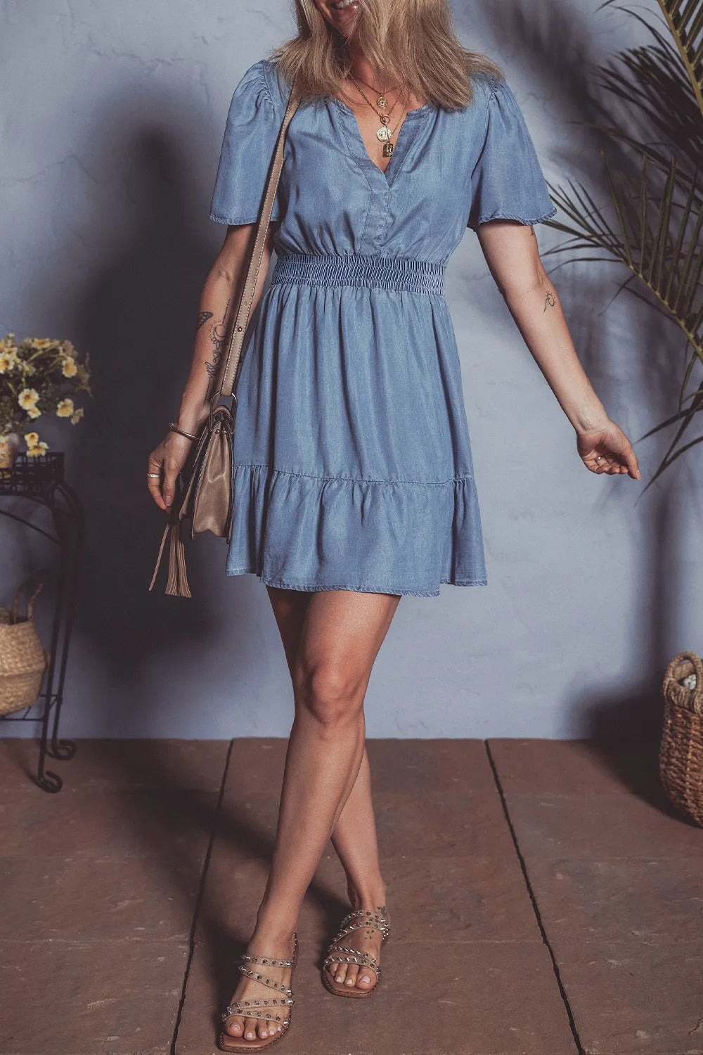 Dusty blue denim mini dress with ruffled hem, smocked bodice, and flutter sleeves from Trendsi.