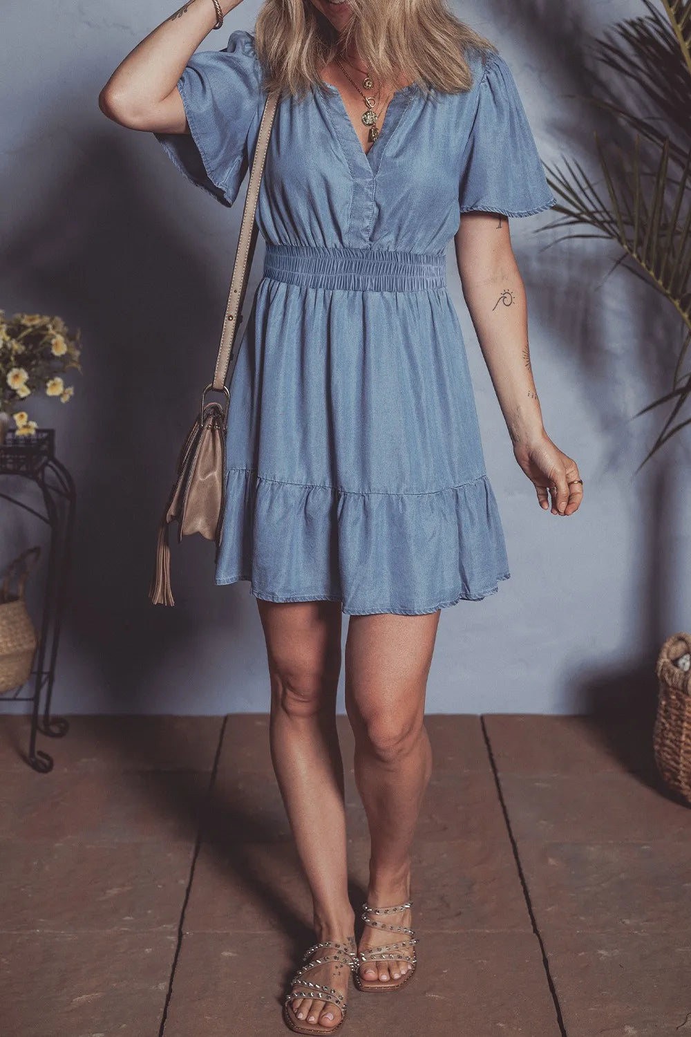 Dusty blue denim mini dress with ruffled hem, smocked bodice, and flutter sleeves from Trendsi.