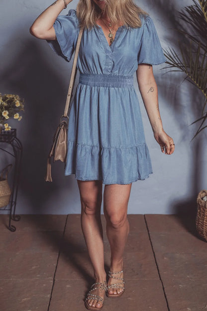 Dusty blue denim mini dress with ruffled hem, smocked bodice, and flutter sleeves from Trendsi.