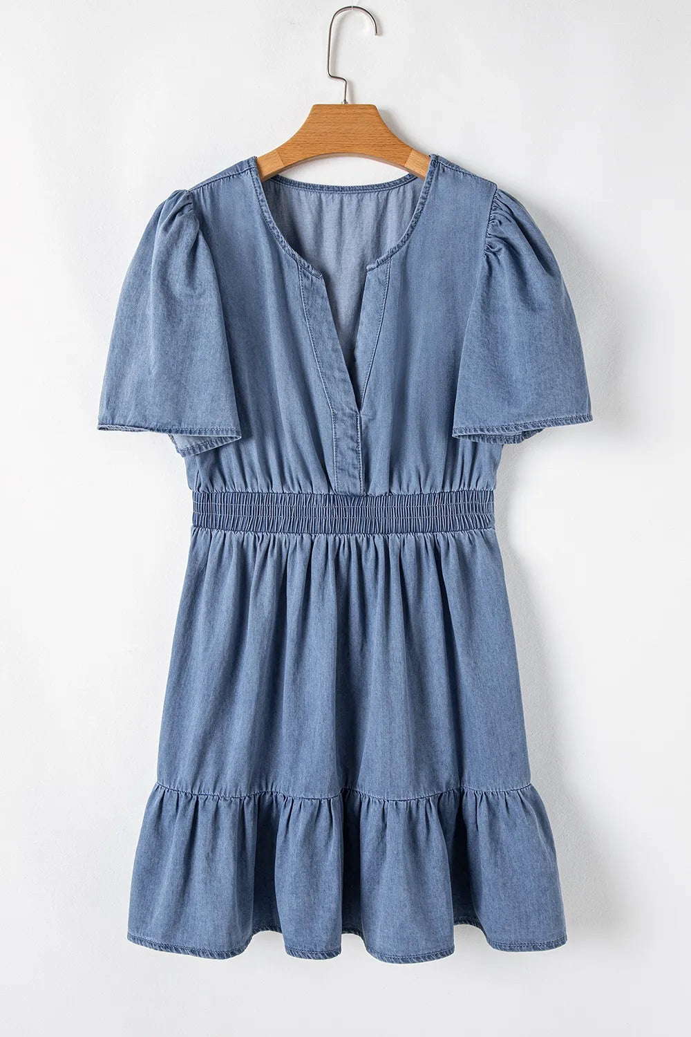 Dusty blue denim mini dress with ruffled hem, smocked waist, and flutter sleeves by Trendsi, perfect for casual summer wear.