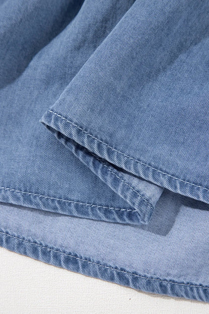 Dusty blue denim mini dress with ruffled hem, smocked waist, and flutter sleeves from Trendsi. Perfect for casual summer wear.