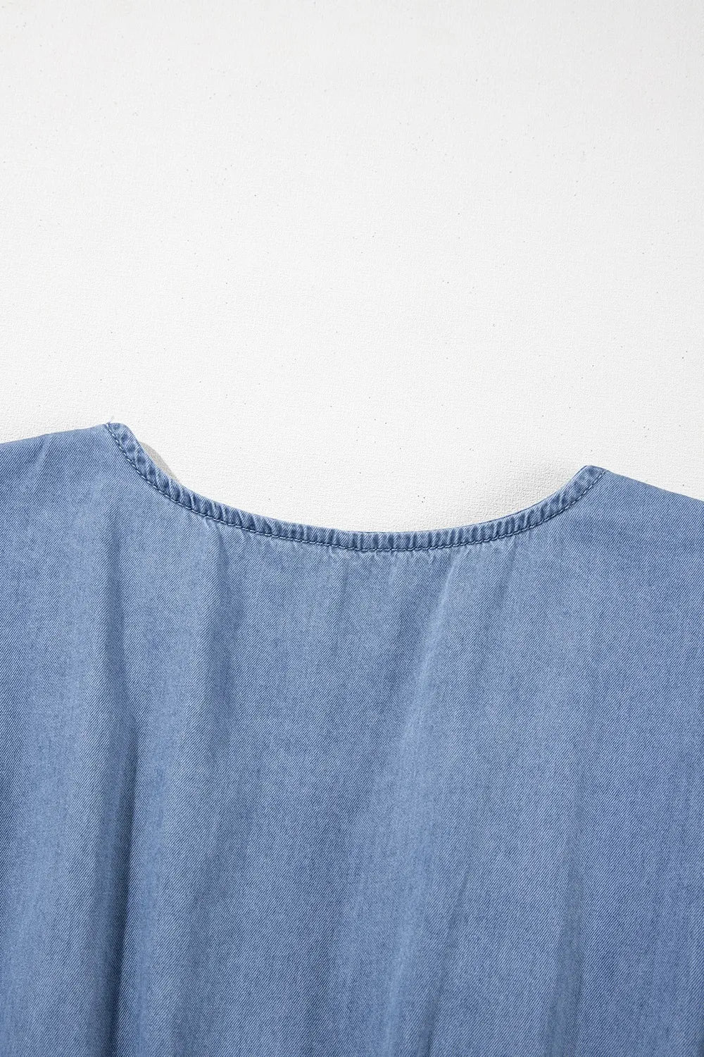 Dusty blue denim mini dress with ruffled hem, smocked bodice, and flutter sleeves from Trendsi.
