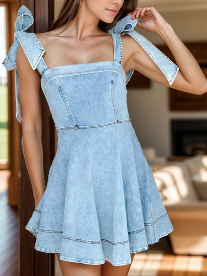 Dusty blue denim dress with square neckline and tie shoulder straps, by Trendsi, displayed on a hanger.