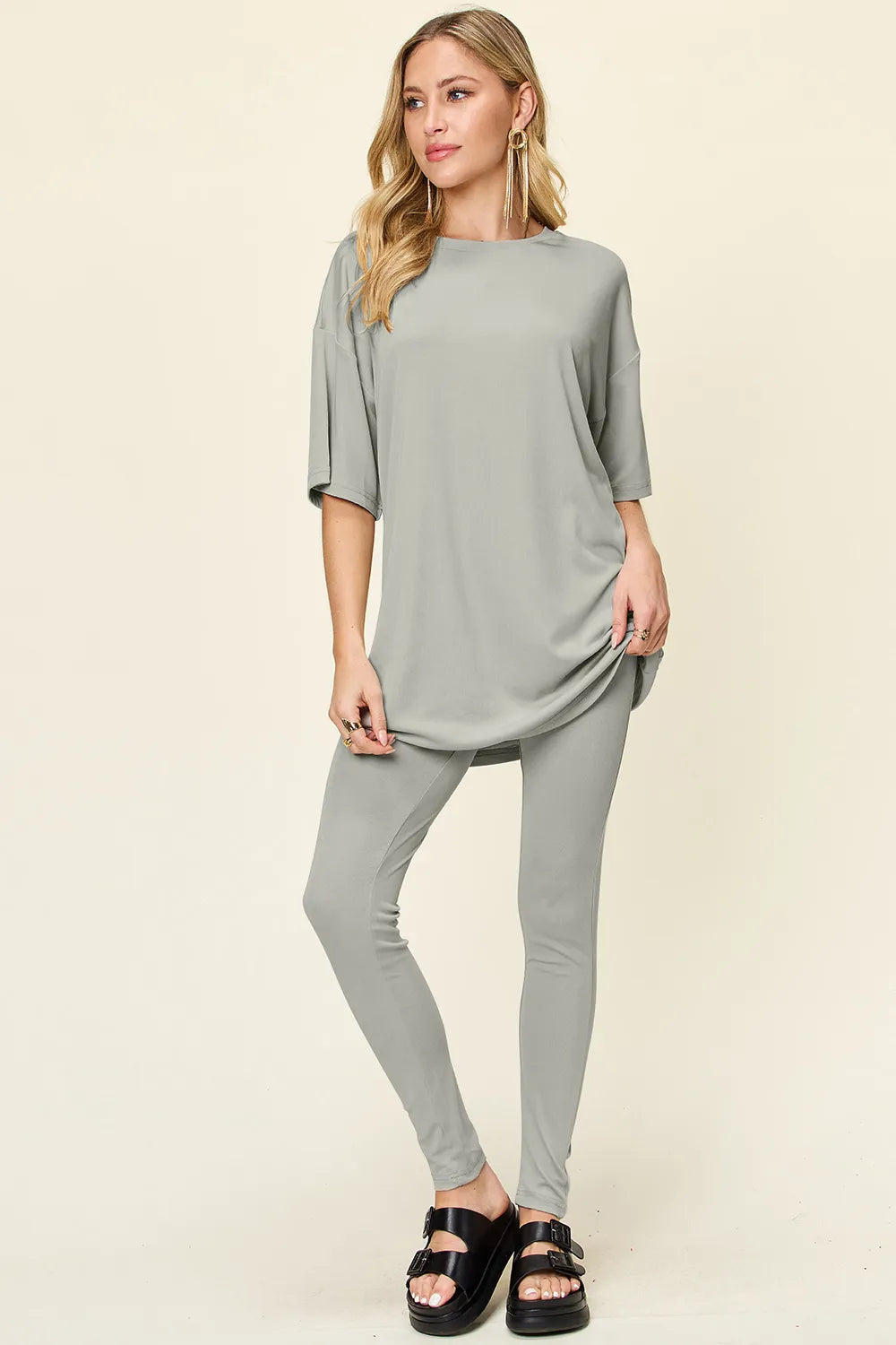 Dusty pink Trendsi double take full size round neck dropped shoulder t-shirt and matching leggings set on model.