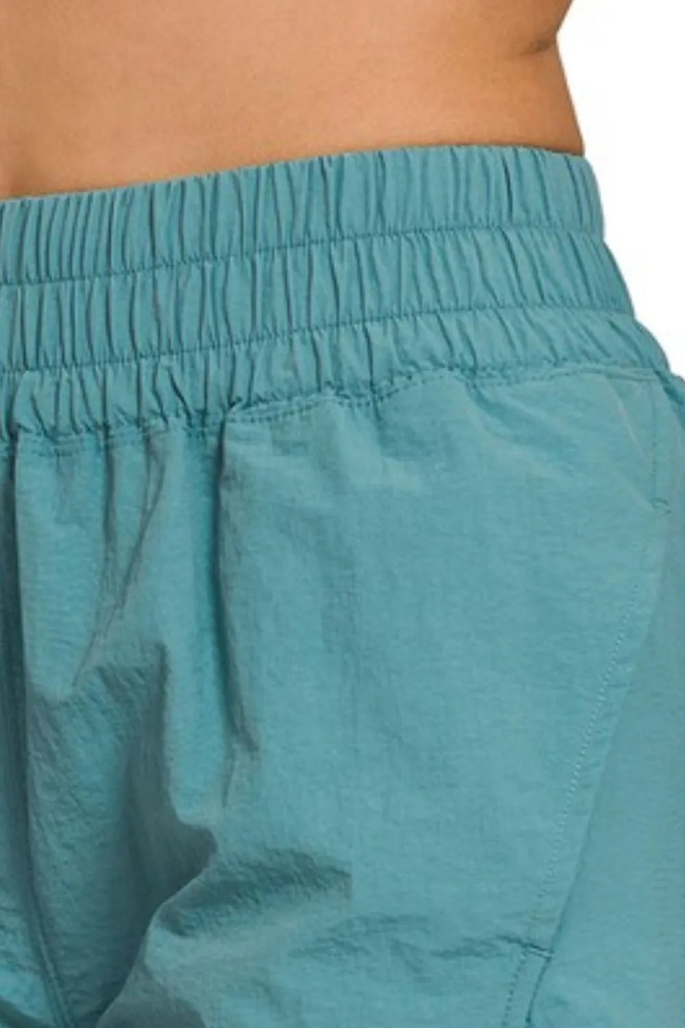 Dusty teal Zenana windbreaker running shorts with smocked waistband, lightweight and comfortable for active wear.