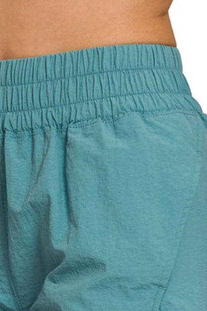 Dusty teal Zenana windbreaker running shorts with smocked waistband, lightweight and comfortable for active wear.
