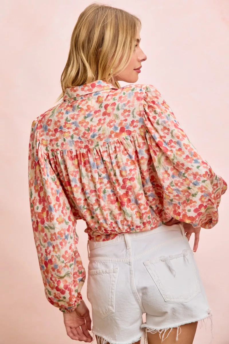 Trendi floral print crop shirt with tie hem detail, lightweight fabric, short sleeves, and vibrant botanical design.