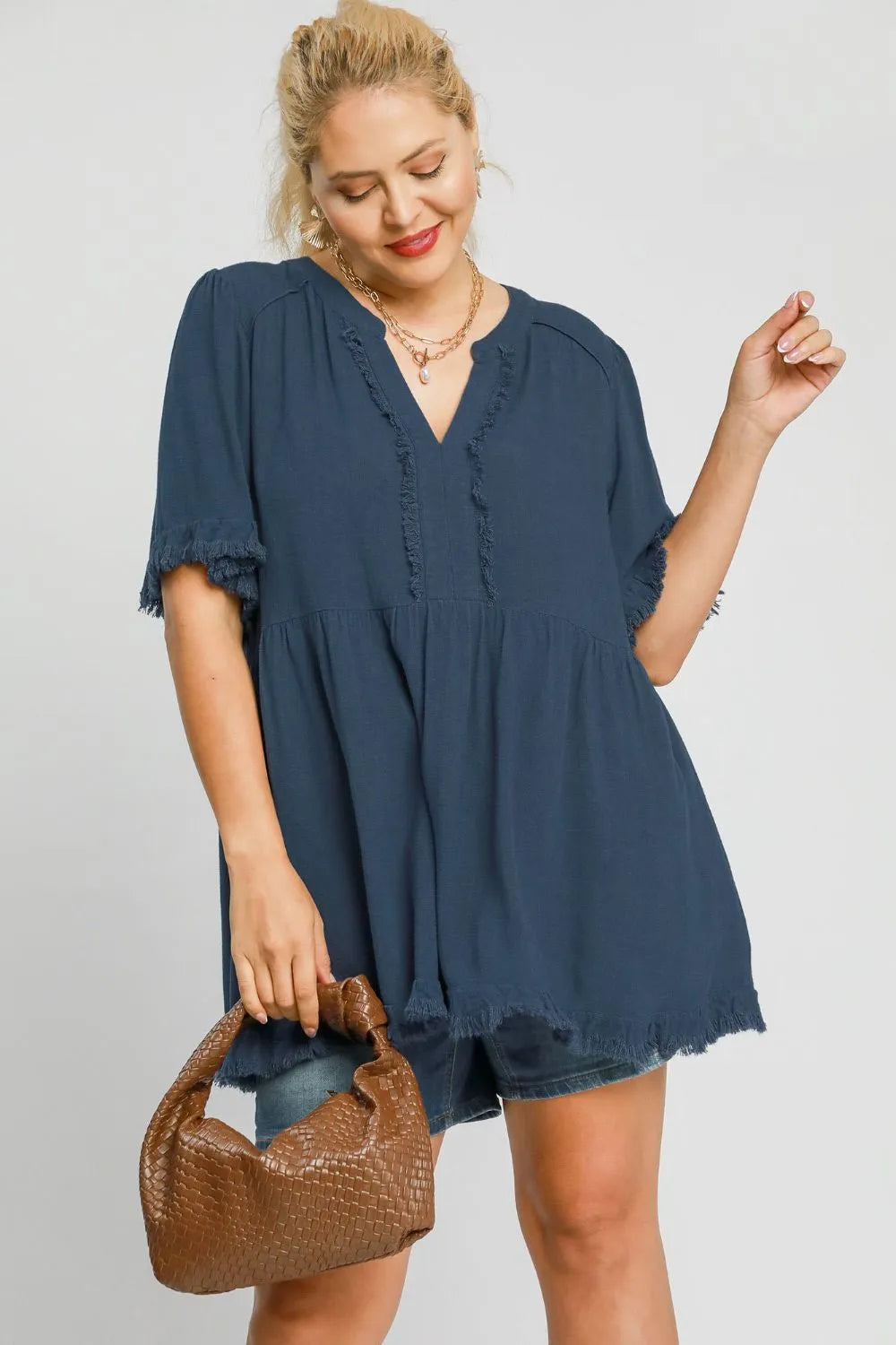 French blue Umgee plus size linen babydoll blouse with raw hem and notched details, styled for a relaxed, feminine look.