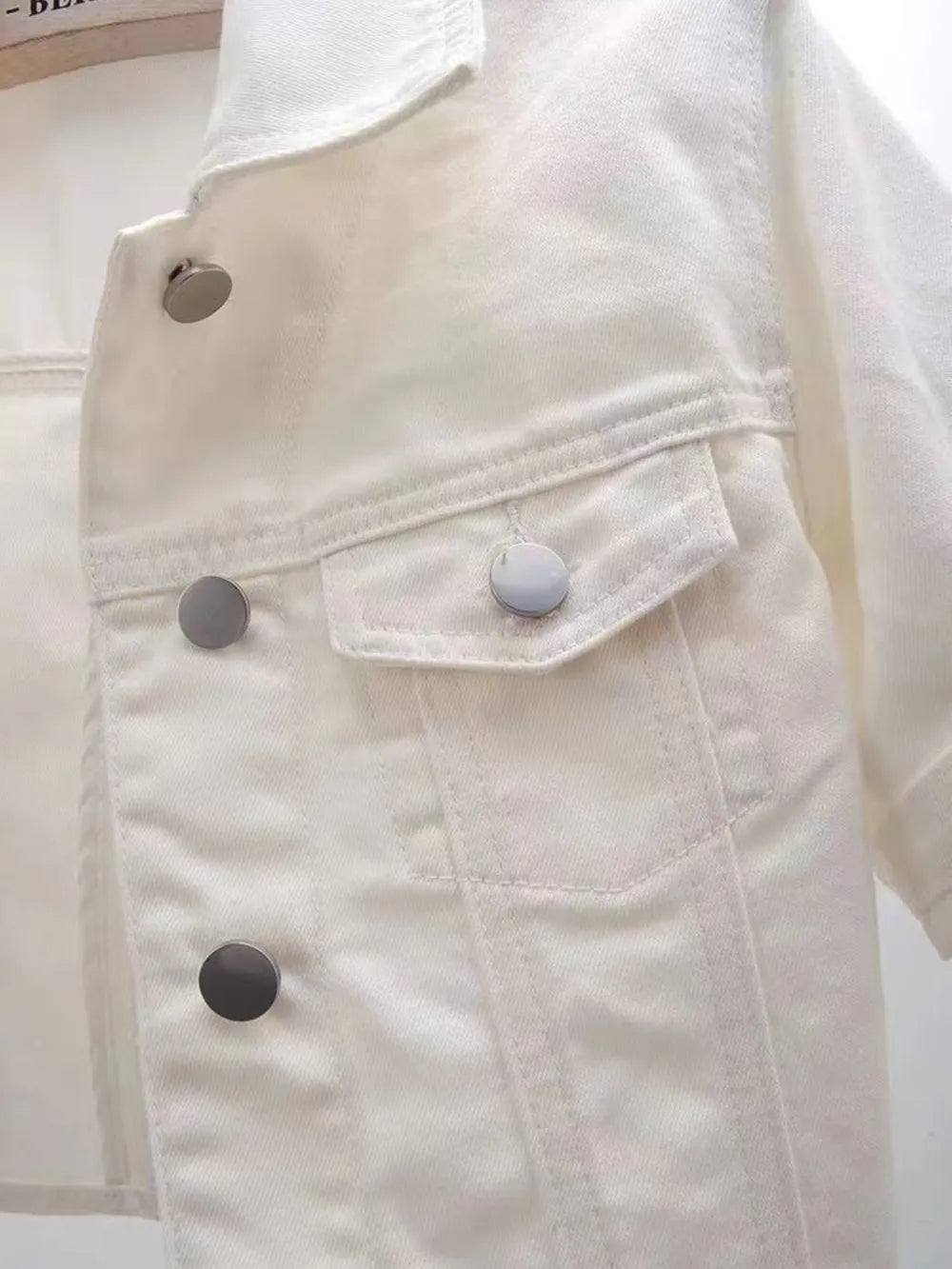 Plus size cropped denim jacket by Trendsi, showcasing classic blue denim fabric with a fitted, stylish design.
