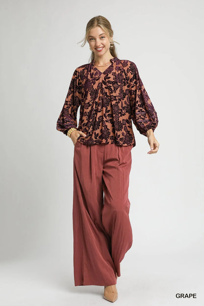 Umgee floral velvet blouse by Trendsi featuring balloon sleeves and a vibrant floral pattern, perfect for stylish, comfortable wear.