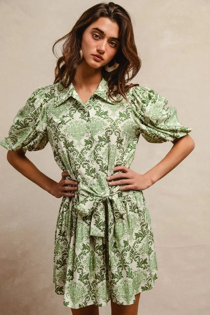 Green and cream floral short sleeve mini shirt dress with a tied waist from Trendsi, featuring a stylish and comfortable design.