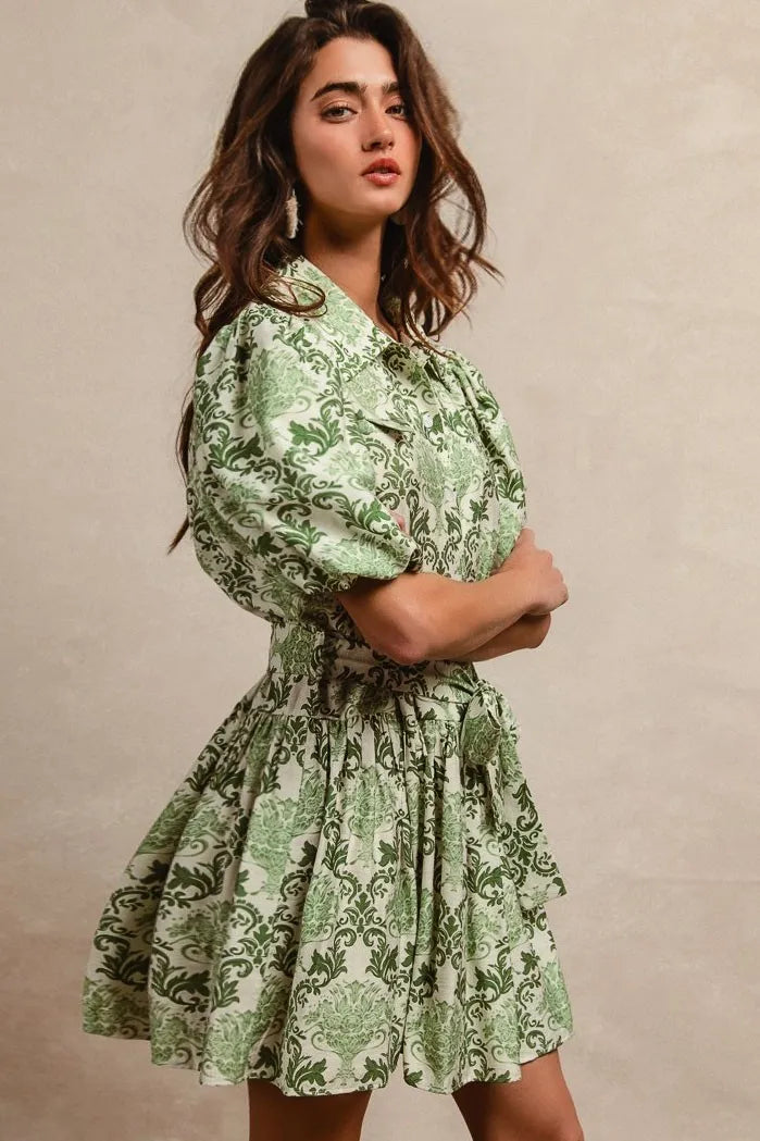 Green and cream floral short sleeve mini shirt dress with tie detail from Trendsi, styled for a casual summer look.