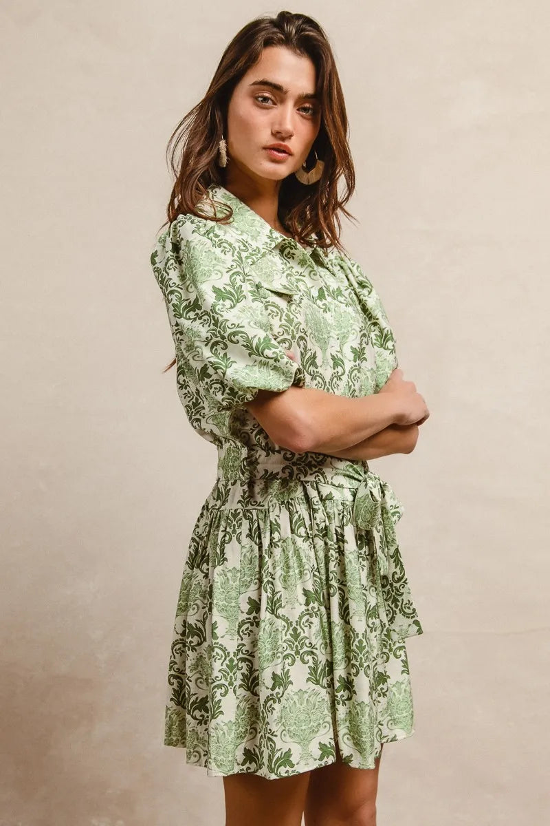 Green and cream floral mini shirt dress with tied waist and short sleeves, by Trendsi, styled with a casual summer look.