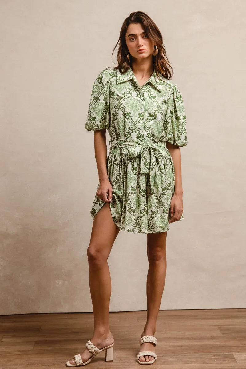 Green and cream BiBi Tied Floral Short Sleeve Mini Shirt Dress by Trendsi, featuring a relaxed fit and tied waist detail.
