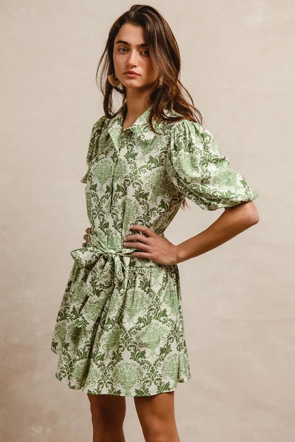 Green and cream floral mini shirt dress with tied waist and short sleeves, by Trendsi, styled on a model.