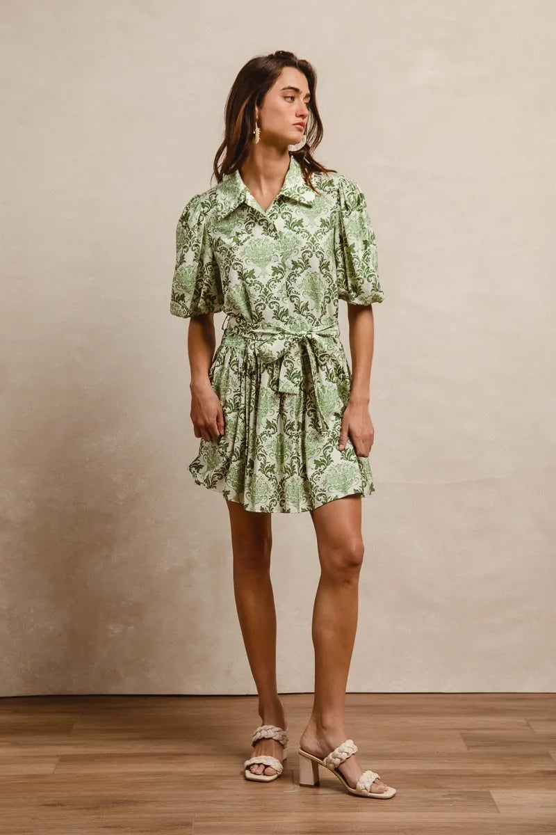 Green and cream floral mini shirt dress with tie detail and short sleeves by Trendsi, perfect for casual summer wear.