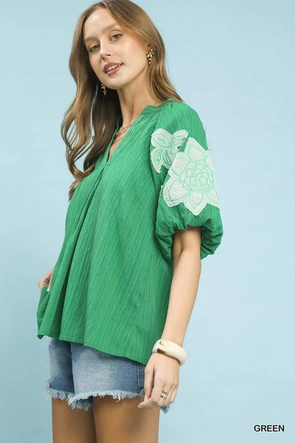 Green Umgee embroidered balloon sleeve blouse with notch neckline, featuring detailed embroidery and relaxed fit.