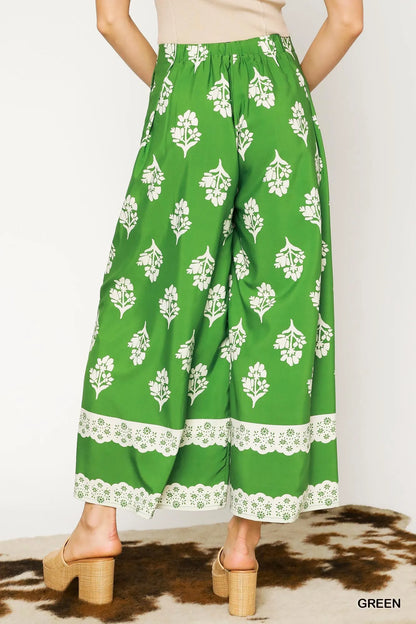 Green floral pleated wide-leg pants by Umgee, showcasing a flowy, stylish design with vibrant floral patterns.