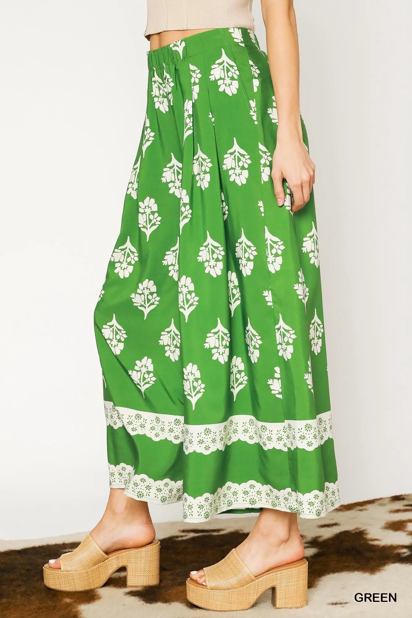 Green Umgee floral pleated wide-leg pants with a relaxed fit and high waist, shown on a model.