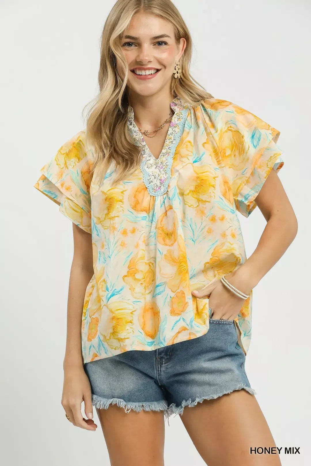 Umgee floral print blouse with crochet lace trim, featuring a mix of colorful floral patterns and delicate lace details.